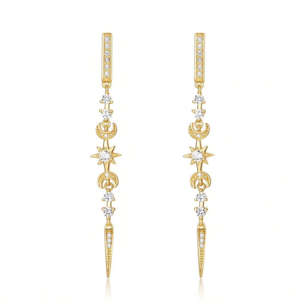 A pair of gold dangle earrings with clear gemstones forming celestial motifs including stars, crescent moons, and a vertical bar at the top, displayed on a clean white background.