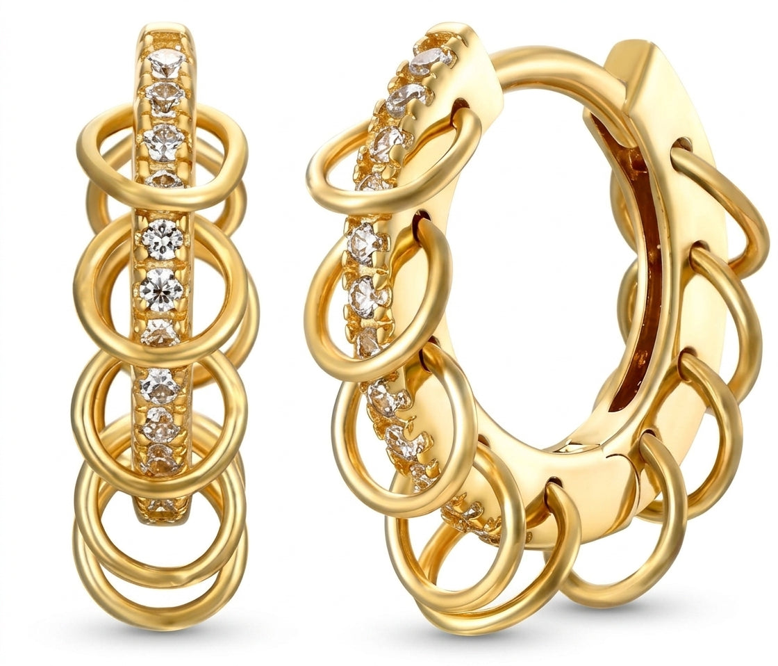 A pair of gold huggie hoop earrings with a multi-layered ring design and a central channel set with clear cubic zirconia stones, shown on a white background.
