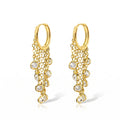 A pair of gold huggie hoop earrings with cascading chain links and clear round gemstones, shown on a clean white background.
